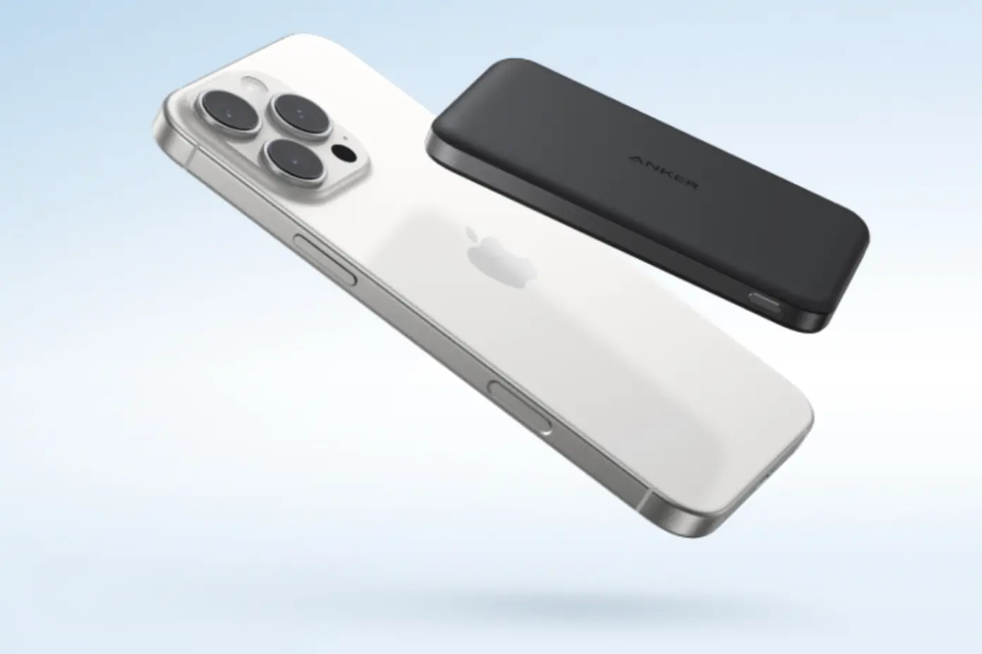 White iPhone floats on blue background with black power bank above it 