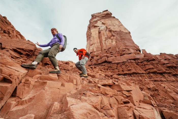 Two people climb rocks