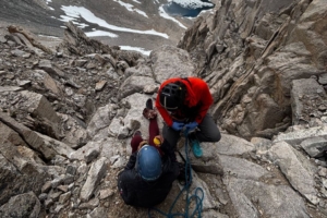 Injured climber with SAR member in mountains