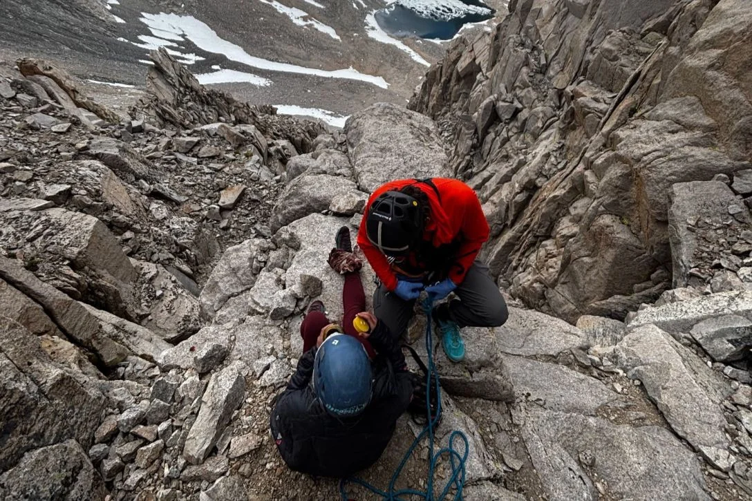 Injured climber with SAR member in mountains