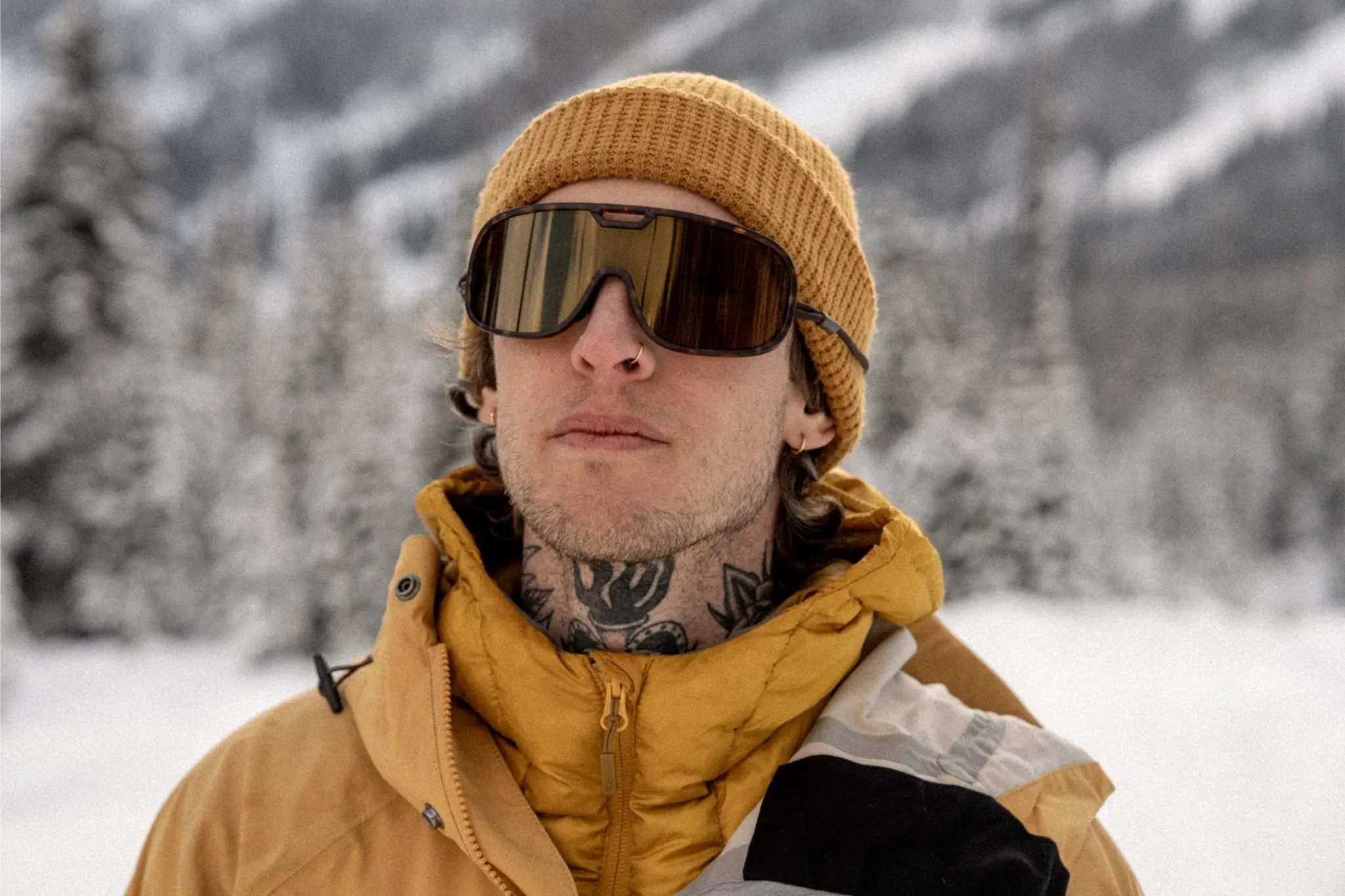 Person in yellow jacket and yellow hat wearing wrap-around sunglasses