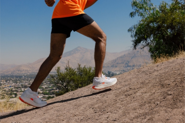 Close up of person's legs running up hill while wearing Merrell ProMorph shoes in white 