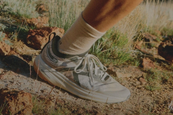 Close-up of the foot of a person running in grey shoes on a trail