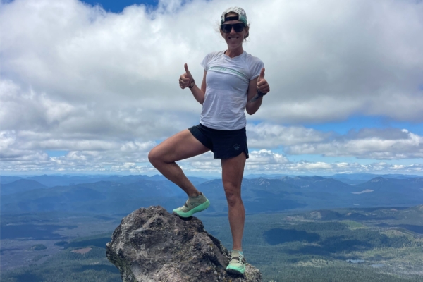 Emily Keddie stands on rock with valley in background