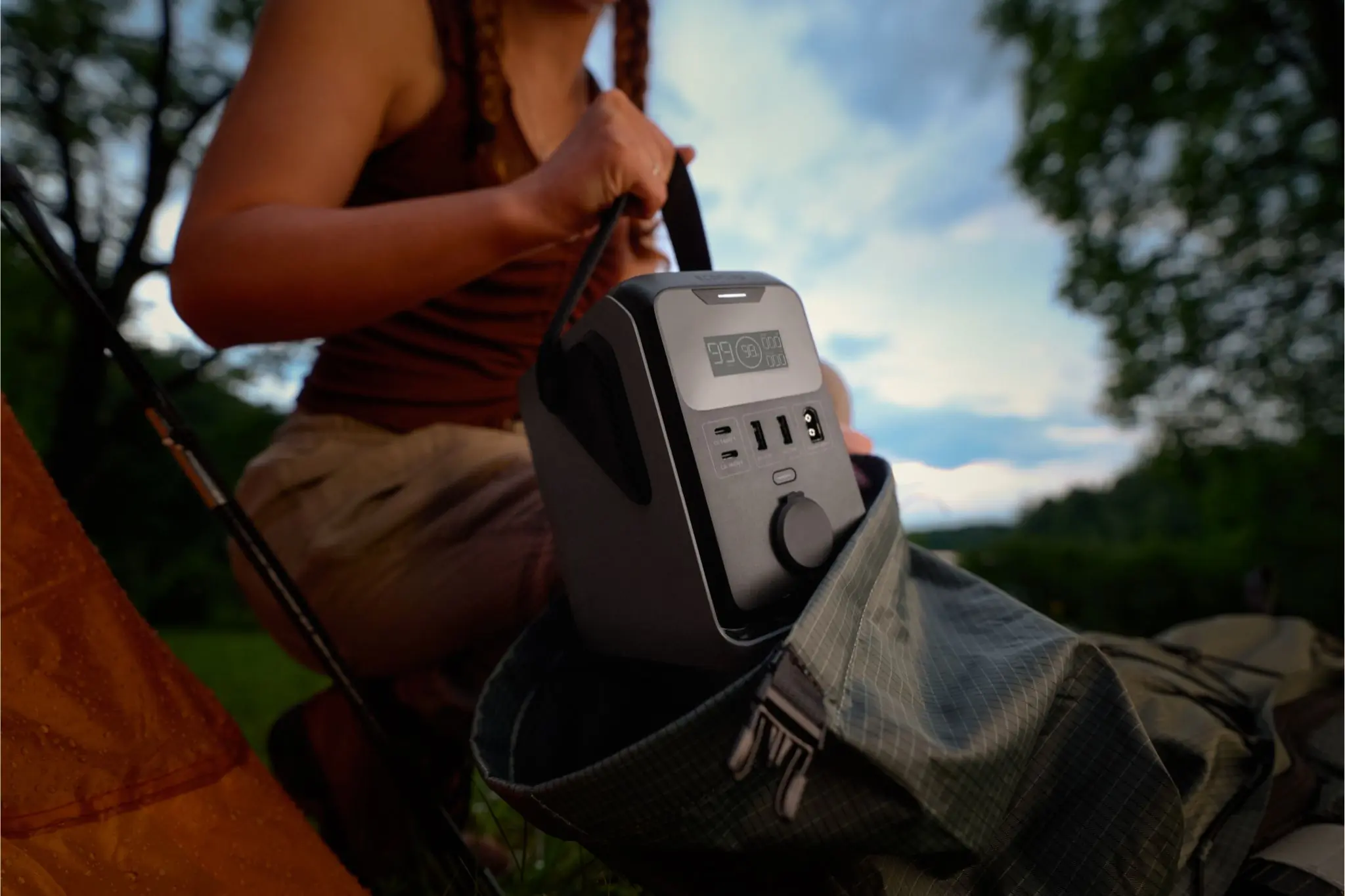 Close up shot of person putting a power station into a backpack