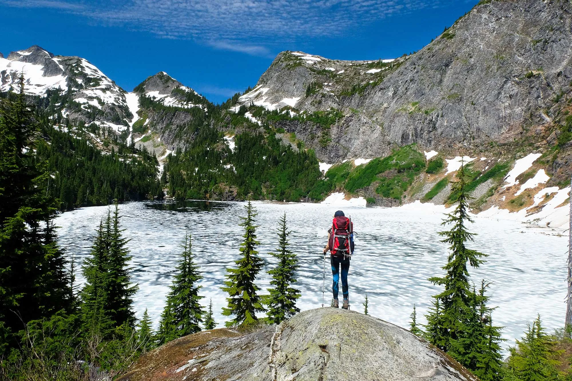 A Woman Hiker Admires Frozen Thorton Lake and Trappers Peak.