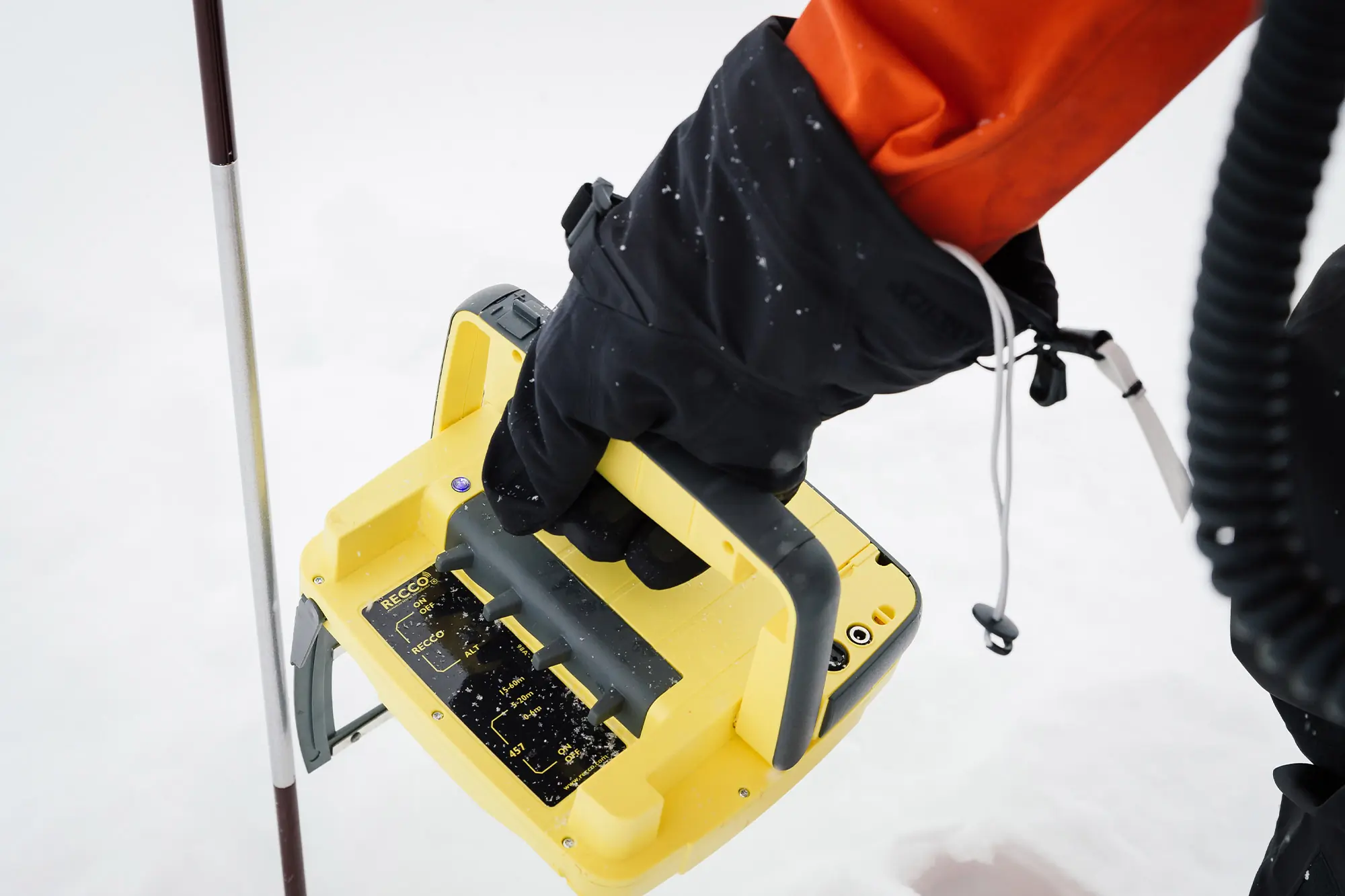 A rescuer grips the RECCO handheld device during avalanche search