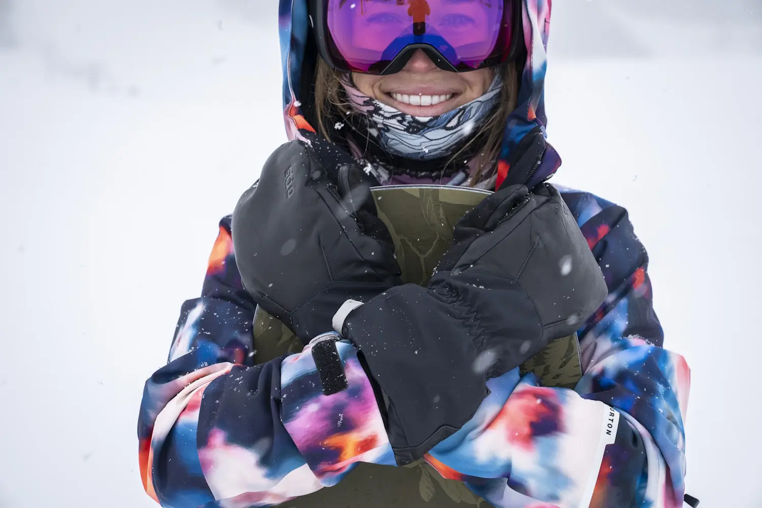 Smiling snowboarder wearing Stio Objective Mittens with arms crossed.