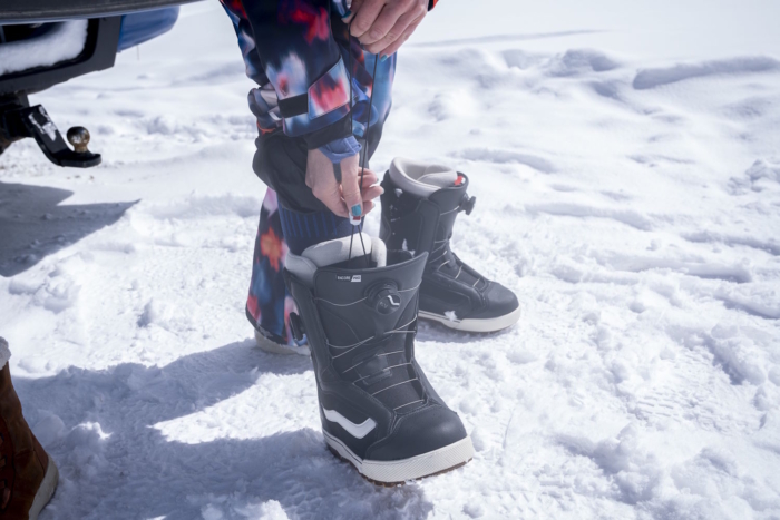 Person tightening the inner liner of Vans Women's Encore Pro Snowboard Boot in snow.