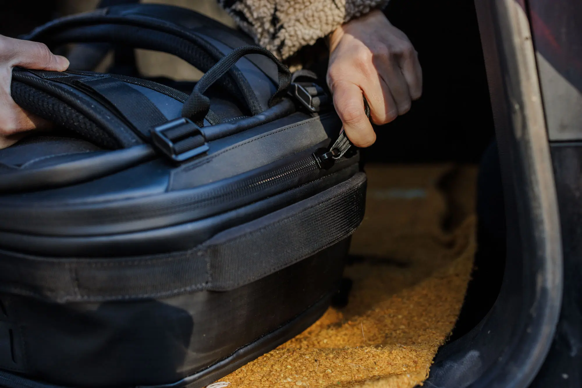 zipping up Nomatic McKinnon 35L Camera Backpack