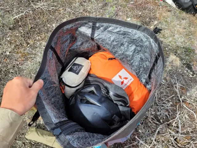 the author holds open the unaweep pack collar, showing how full it is