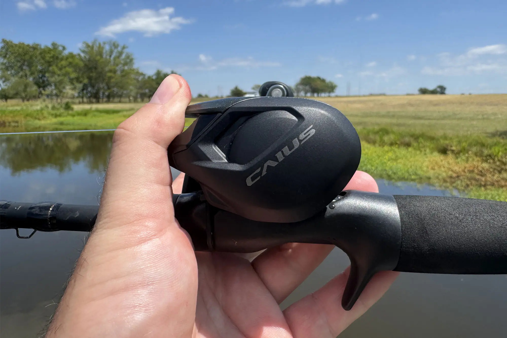 a hand holding the Shimano Caius casting combo