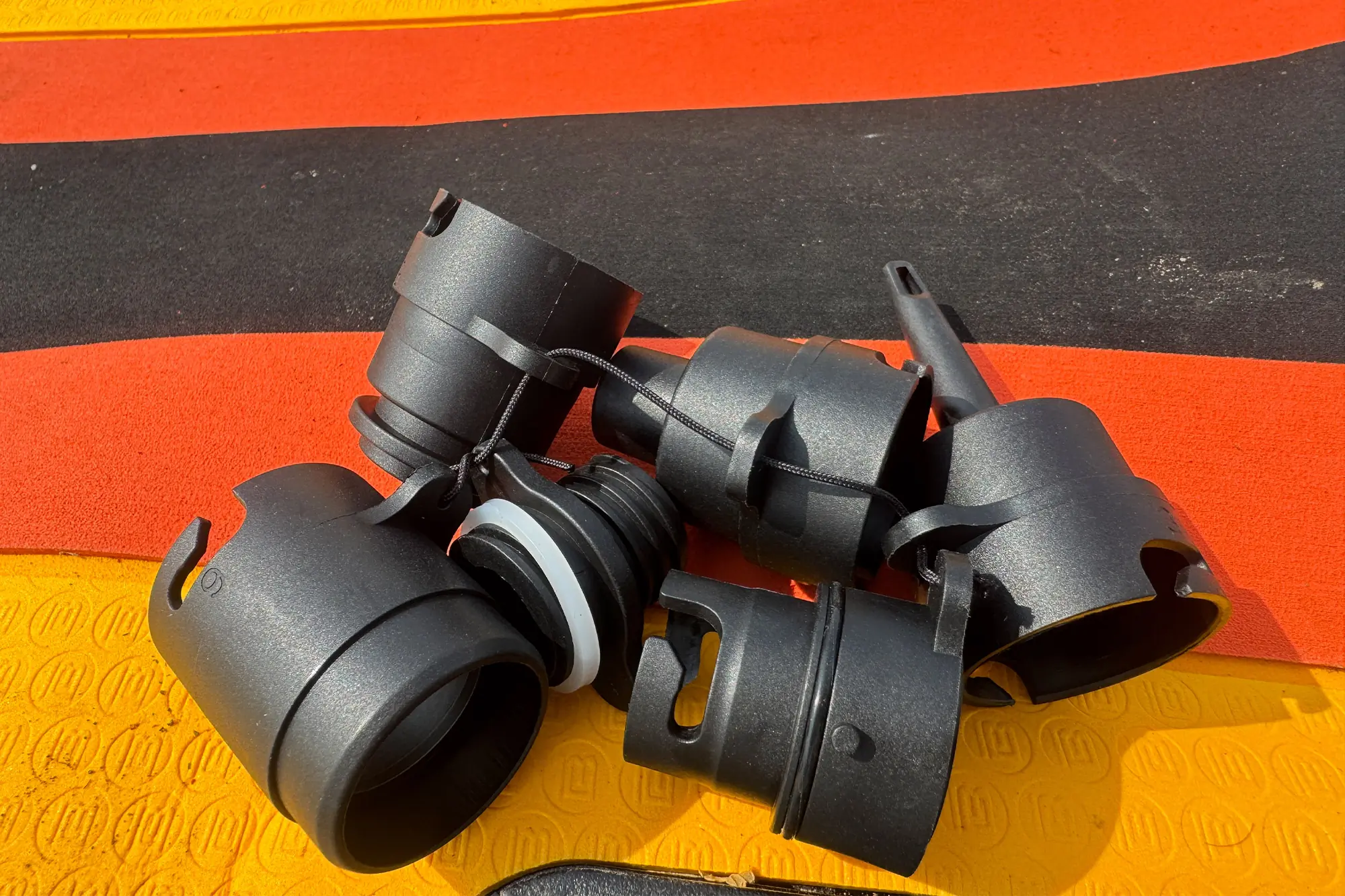 Set of nozzle adapters for the AIRBANK PULSE Pro Electric SUP Air Pump on a paddleboard deck