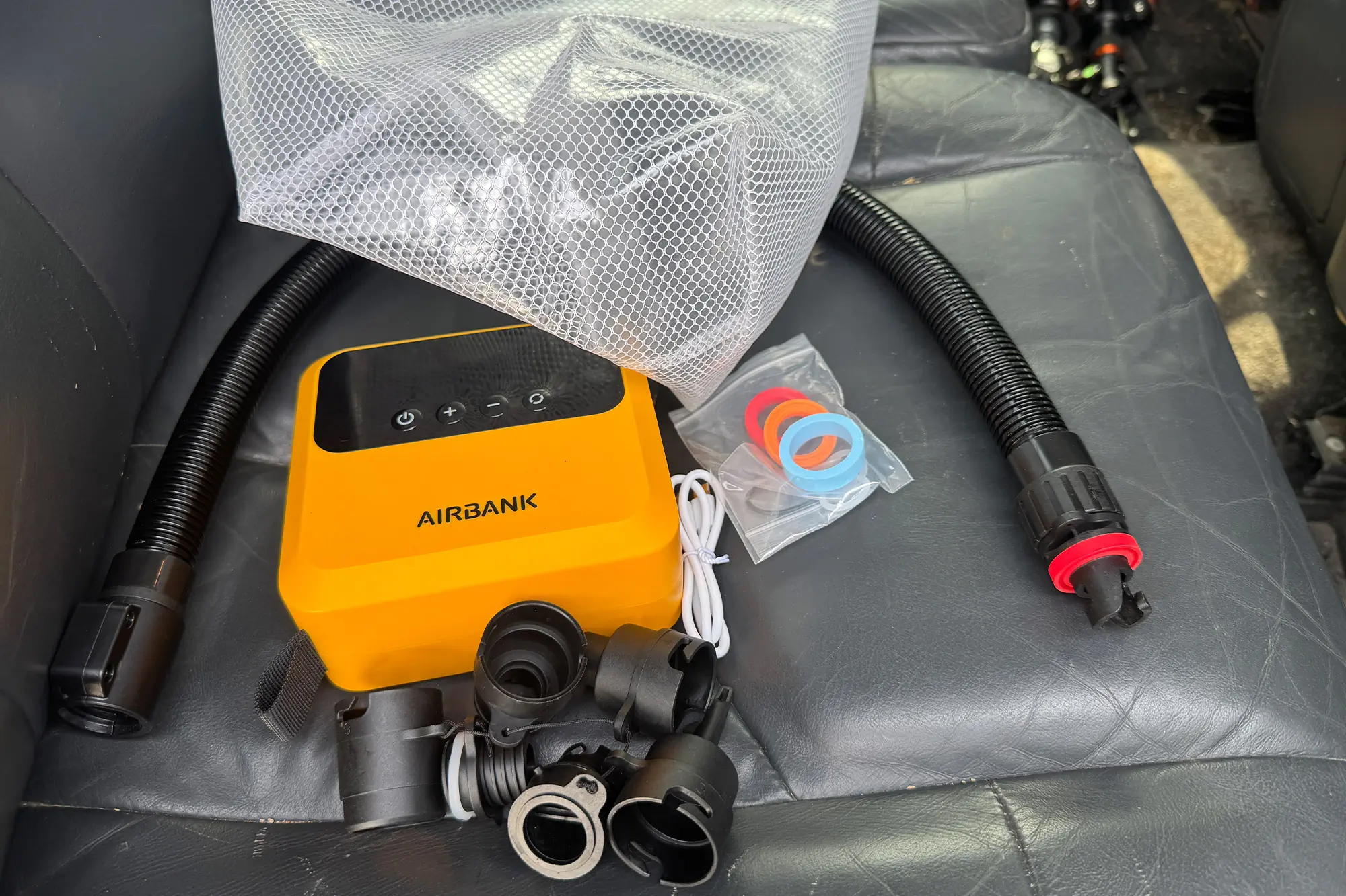 AIRBANK PULSE Pro Electric SUP Air Pump with accessories and hose laid out on a car seat