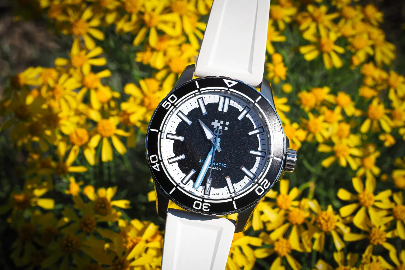 Christopher Ward Trident Reef 44mm with white band black face over yellow flowers