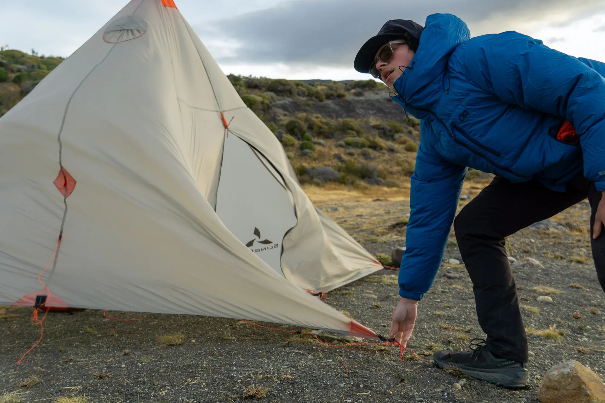 the author setting up the cinder cone in patagonia while a 50 mph wind blows