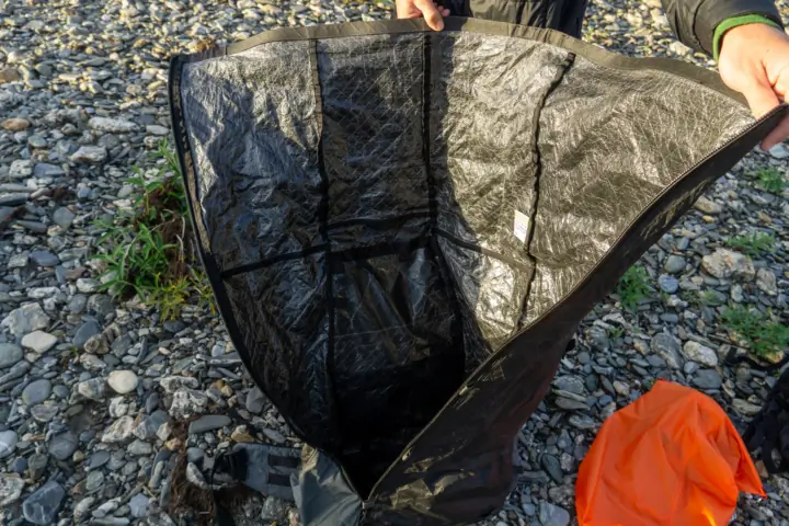 a hiker holds open the fully unzipped unaweep pack, showing the deep access provided