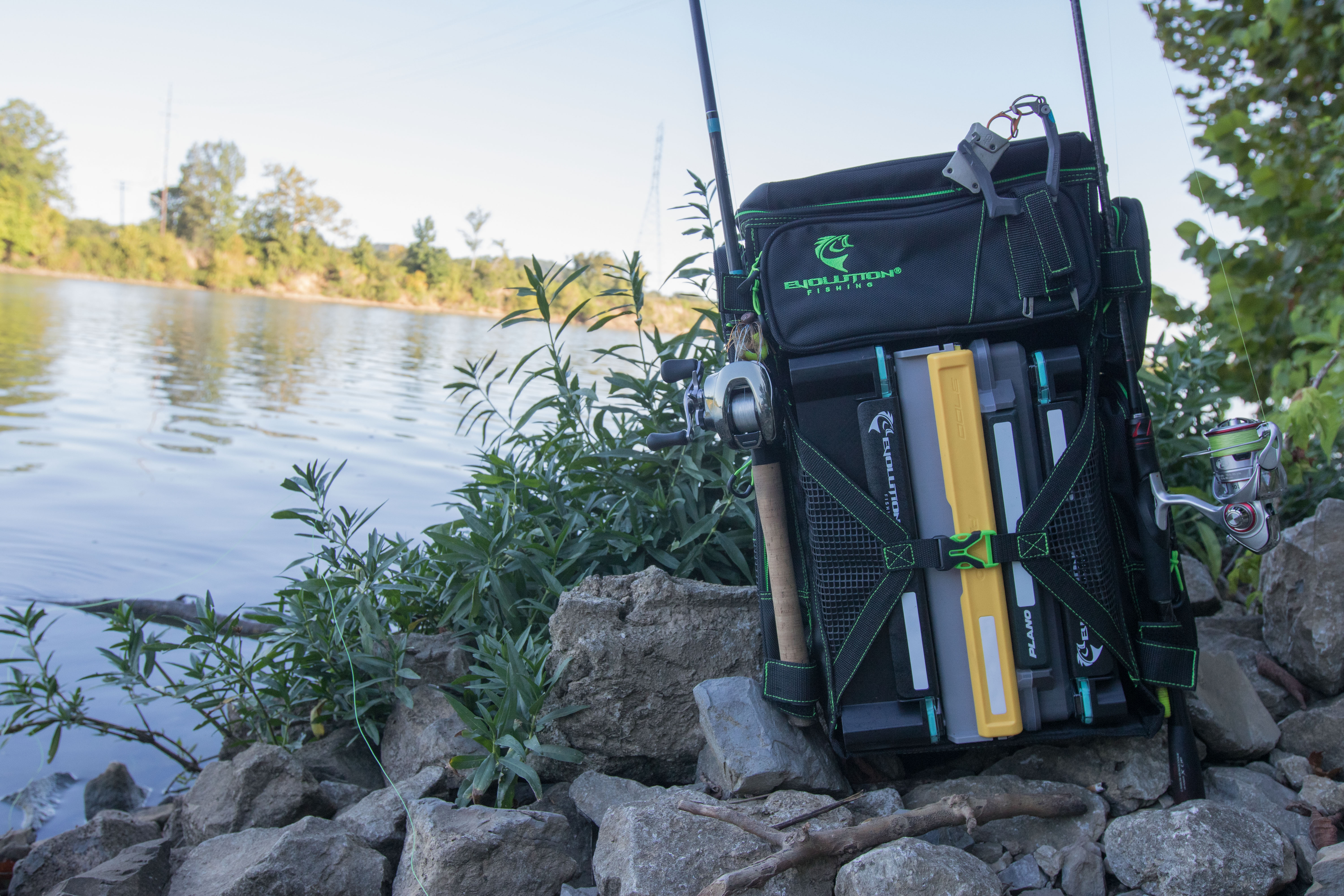 The Evolution Fishing Drift Series Tackle Backpack nest to a river