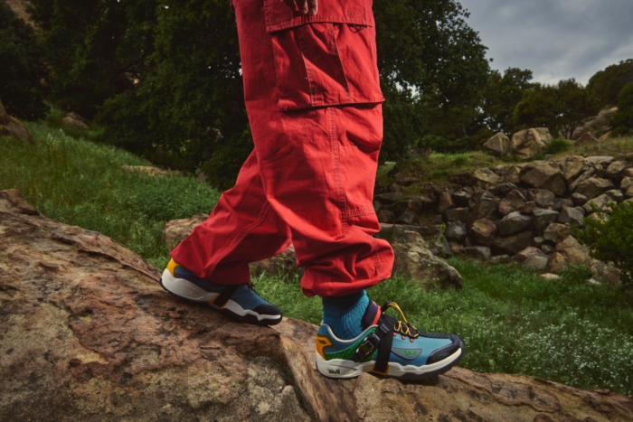 Person walks down rock wearing red pants and blue shoes 