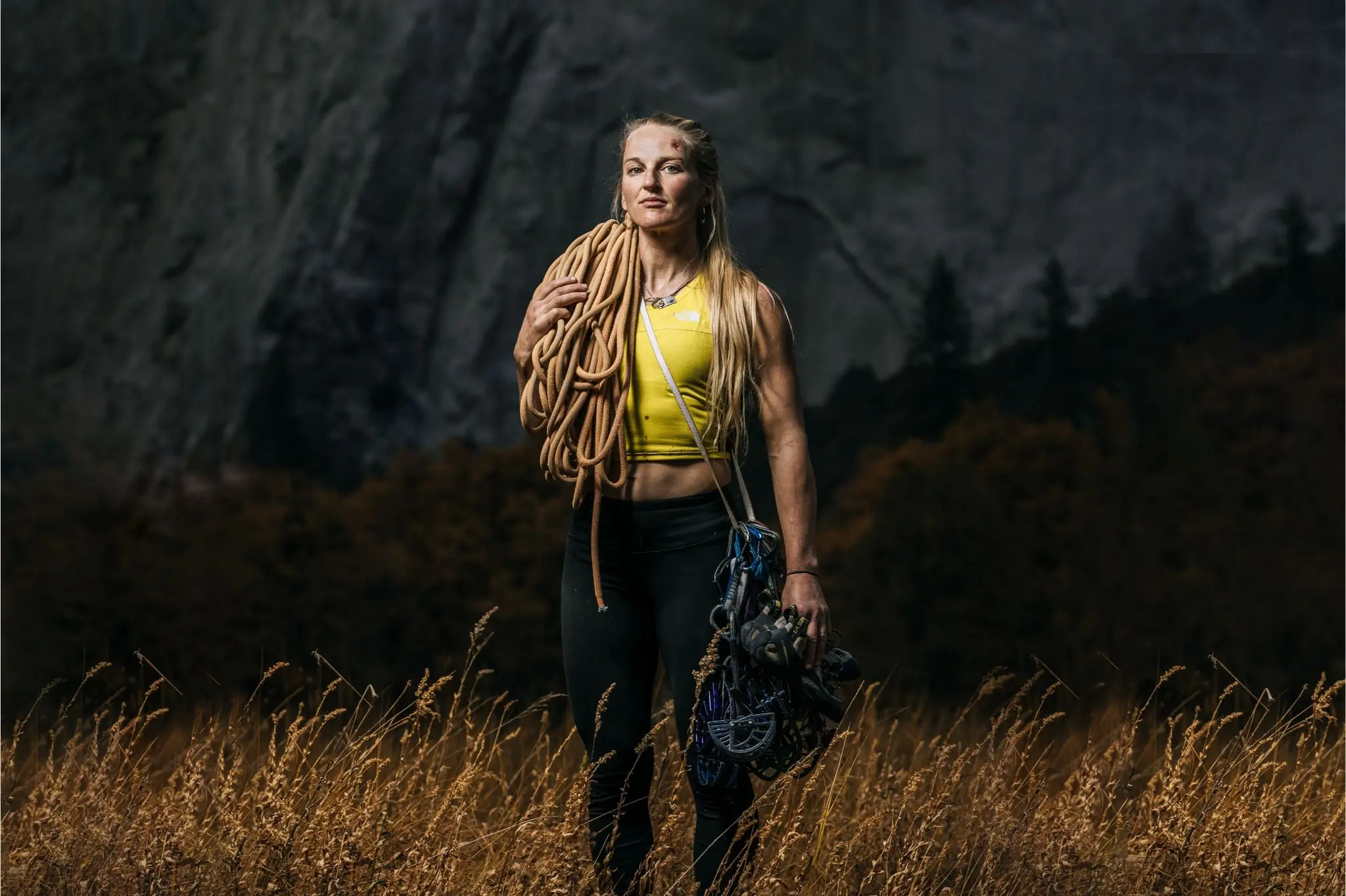 Climber stands in meadow in front of El Cap