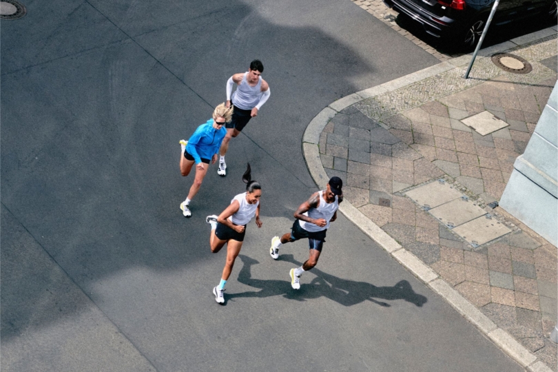 Aerial shot of four people running down road