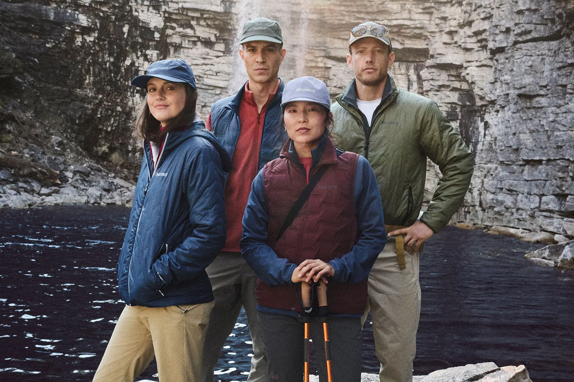 men and women in marmot hiking gear near cliff