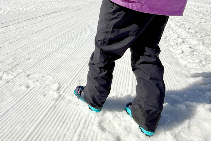 Skier wearing OR Snowcrew pants on groomed snow