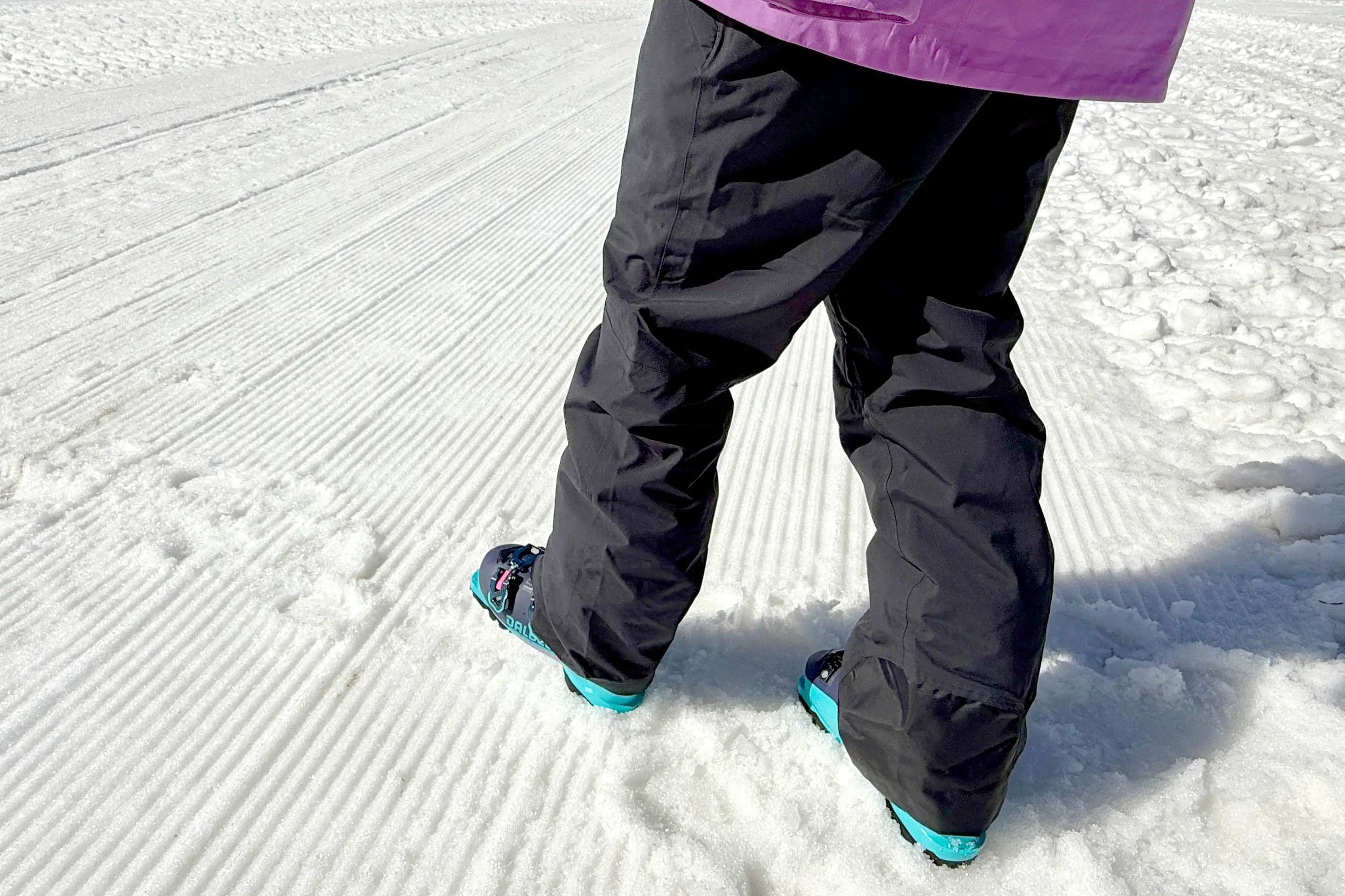 Skier wearing OR Snowcrew pants on groomed snow