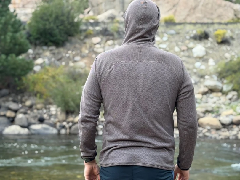 Man wearing the Mountain Hardwear Airmesh Hoody seen from behind near a river