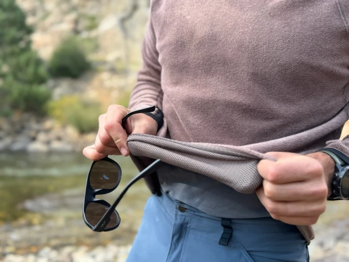 Closeup of the Mountain Hardwear Airmesh Hoody hem being stretched to show fabric layers