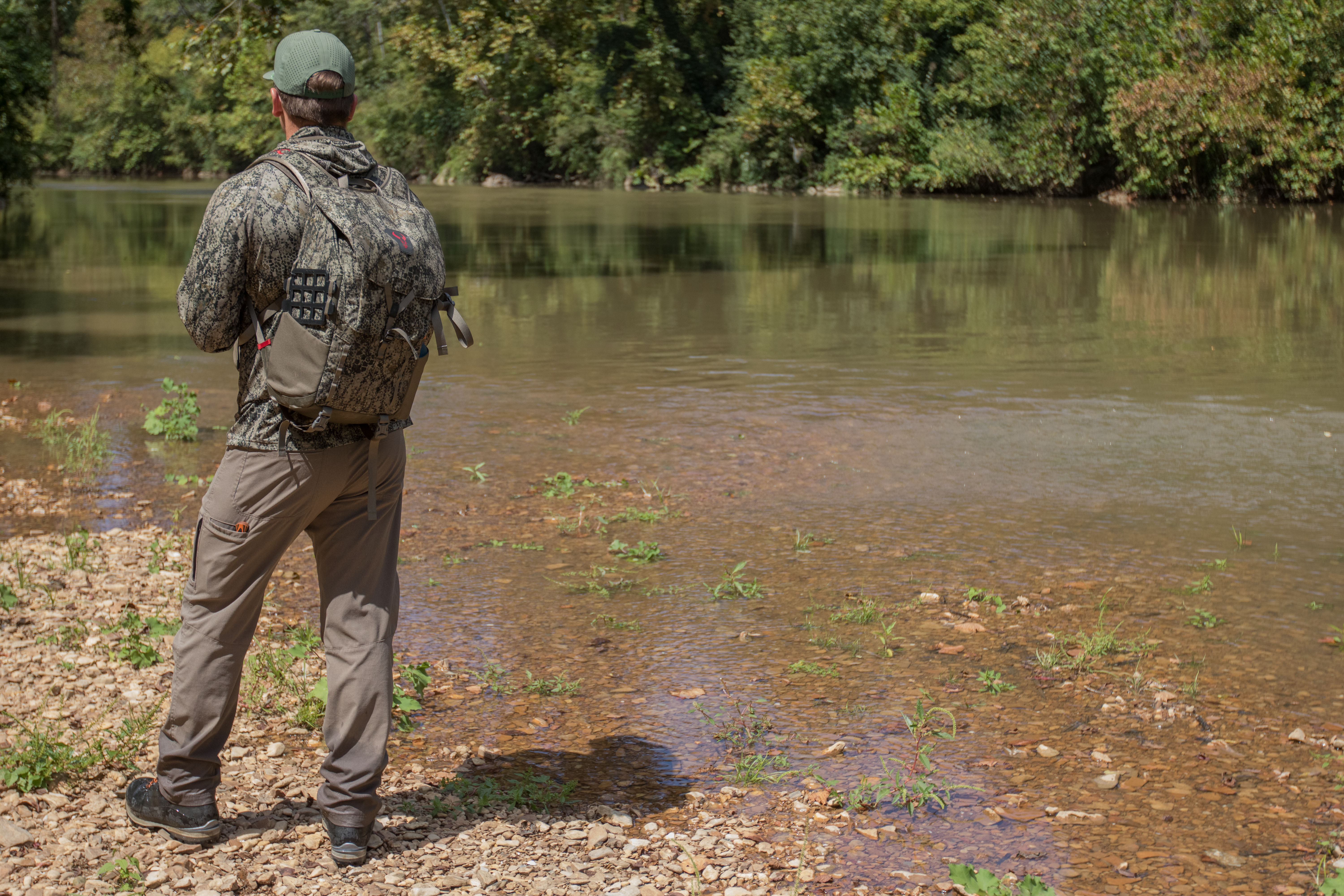 A hunter wearing the Badlands Andaire pants next to a river.