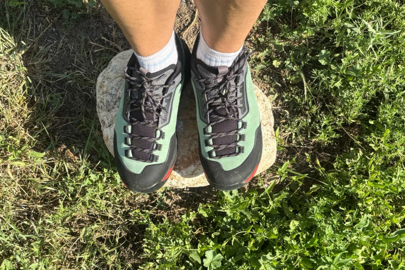 Black Diamond Technician Pro Approach Shoe standing on a flat stone with grass around