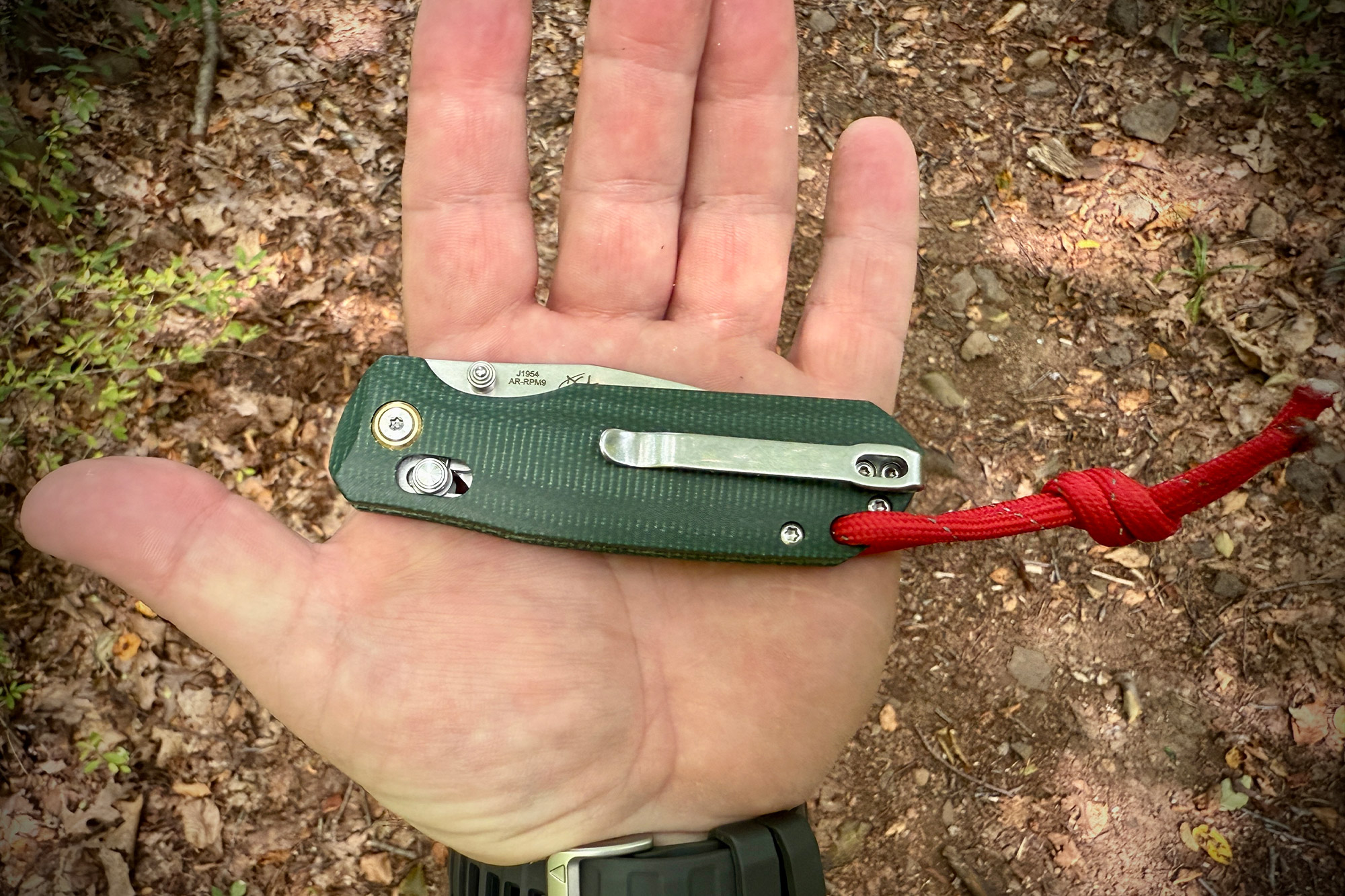 CJRB Maximal folded in hand with a red lanyard