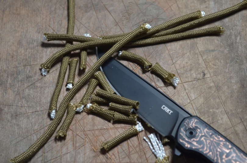 CRKT Q Compact Liner Lock cutting through paracord pieces