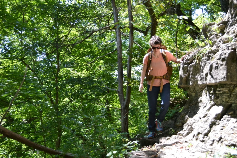 Person hikes on rocky trail in forest