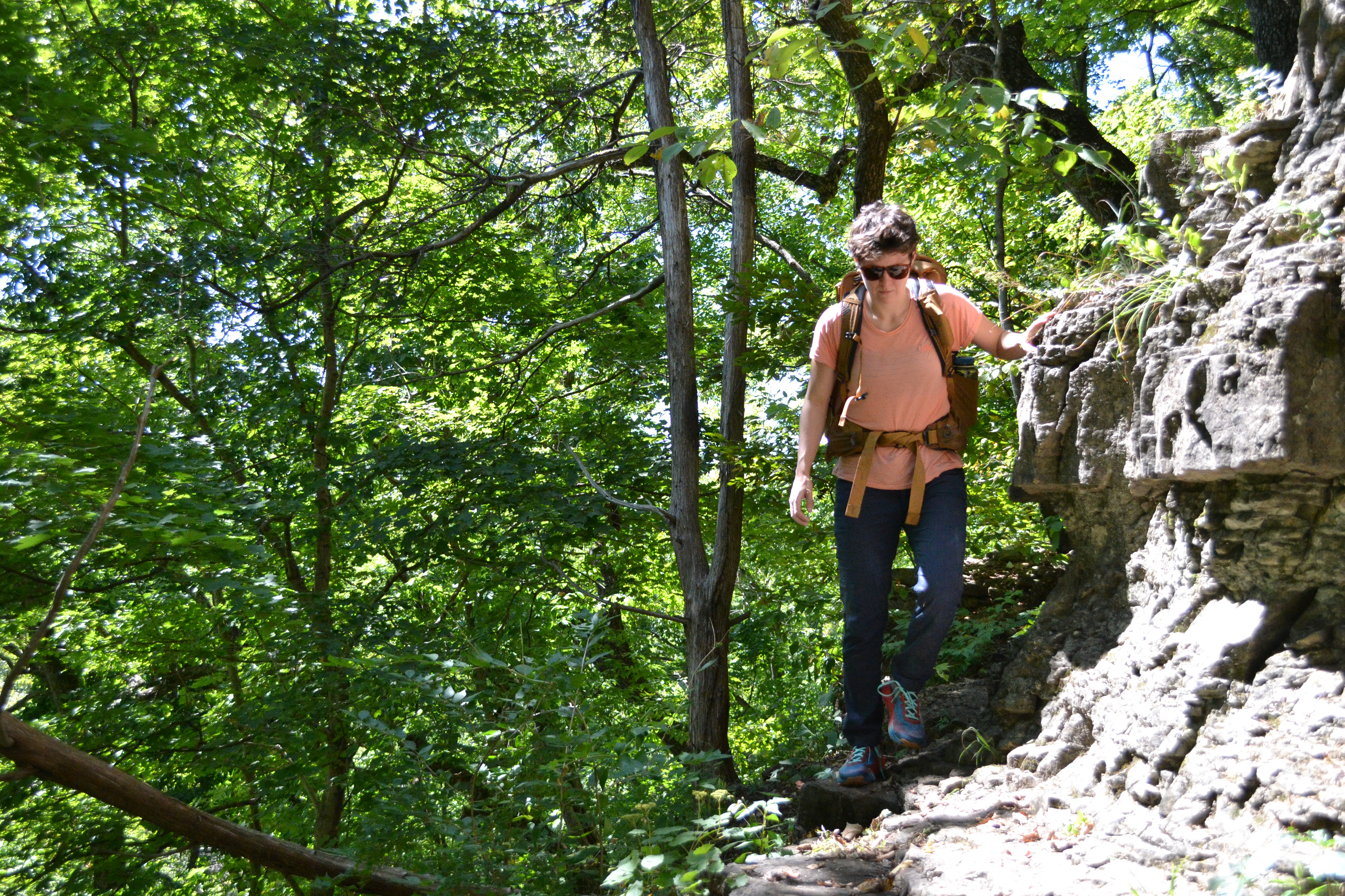 Person hikes on rocky trail in forest