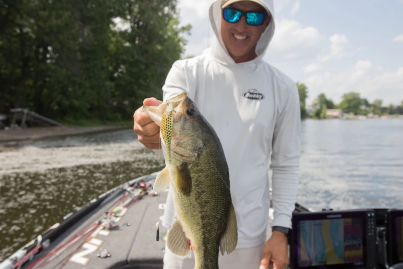 An angler holding a bass with the new Berkley Flux-Gill in its mouth.