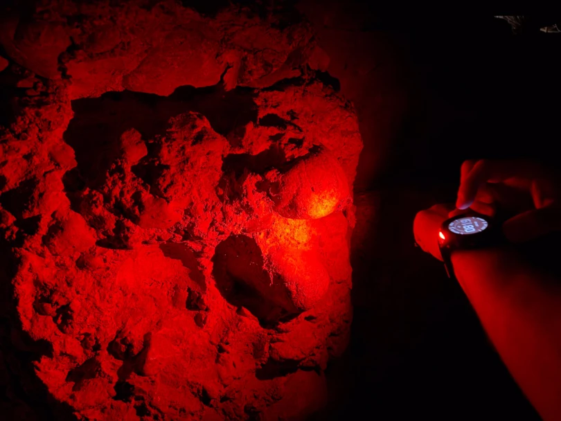 the red led light of the enduro 3 shines on a rock face