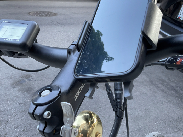 An iPhone 15 Pro on a Nite Ize phone mount on the handlebars of an electric bike.
