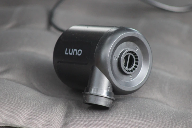 a tight image of the included luno air pump sitting on top of the mattress