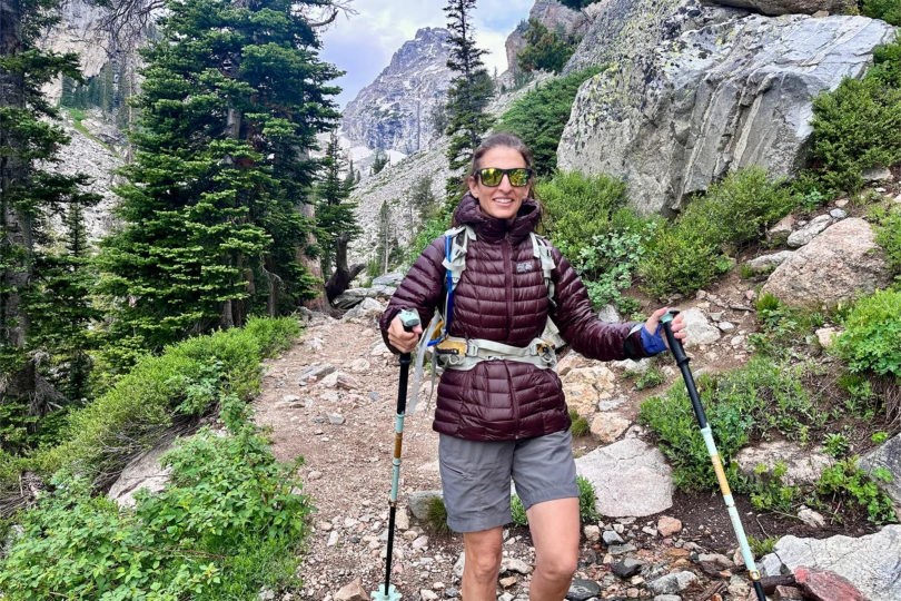 Mountain Hardwear Ghost Whisperer Hoody worn on trail with hood up and trekking poles