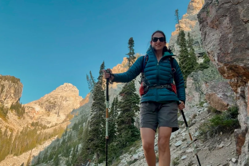Patagonia Down Sweater Hoody on a hiker with trekking poles in the mountains