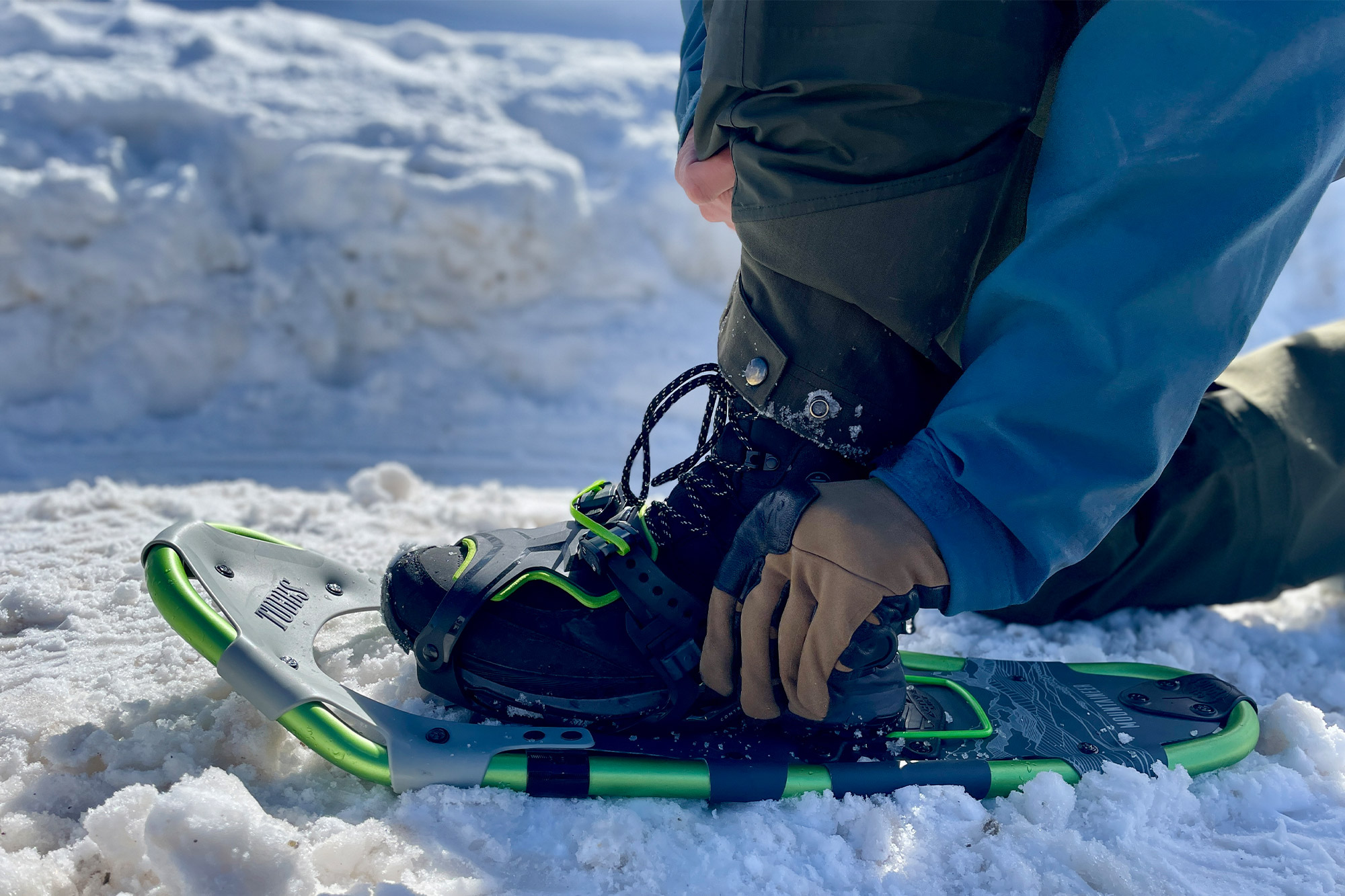 Tubbs Mountaineer snowshoe being strapped onto a boot