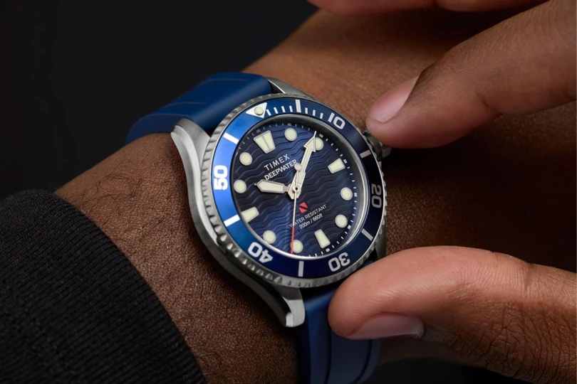 TODO DE CRÁsta de la persona que ajusta el reloj azul Timex en su muñeca