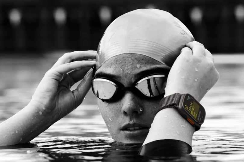 Swimmer in pool with goggles and cap and watch