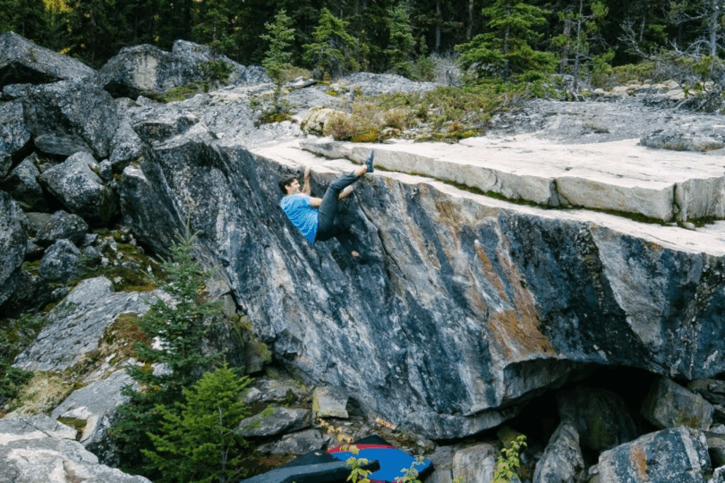 Person climbs up large boudler