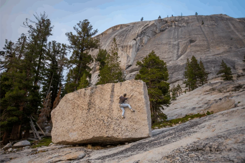 person climbing on boulder