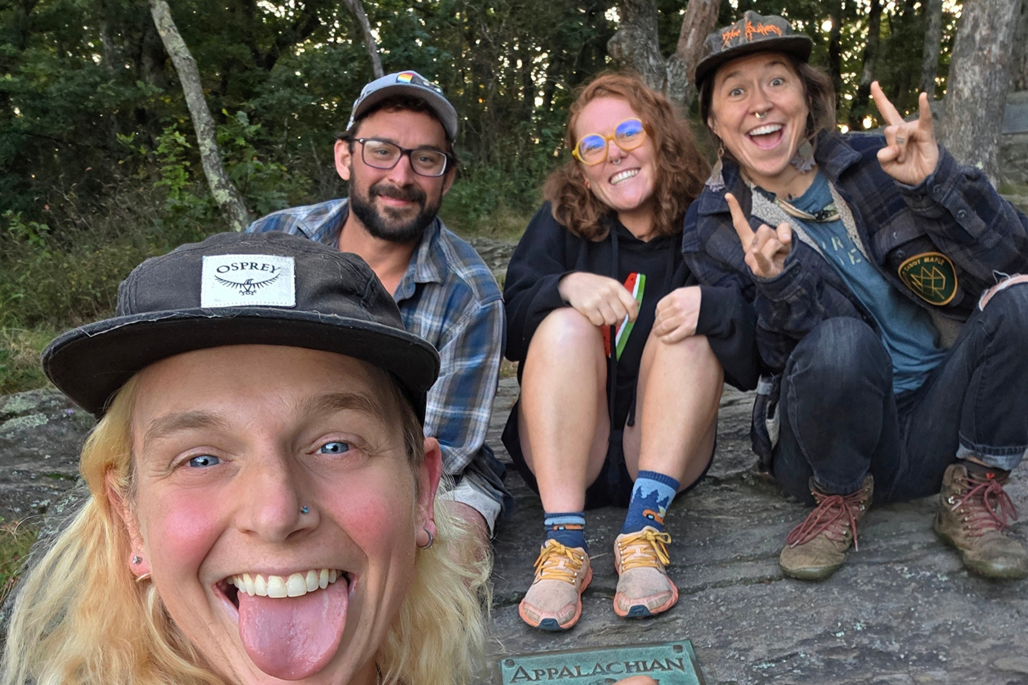 Four people smile in a selfie outdoors