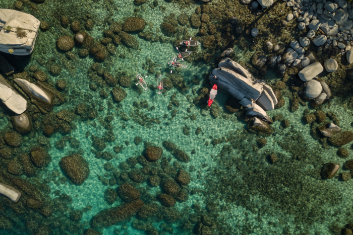 An aerial view of paddlers on a clear lake.