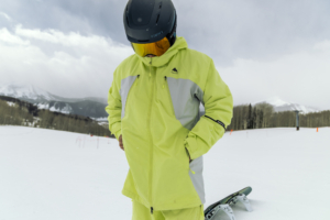 snowboarder standing in snowboard jacket with snowy background